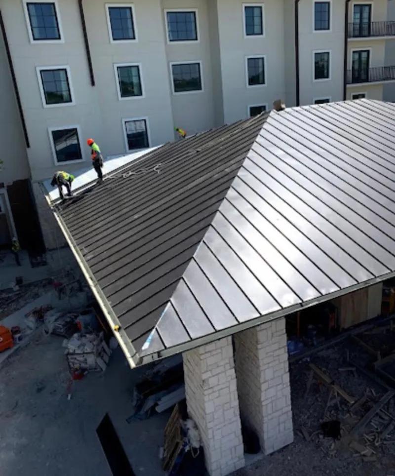 Crew installing standing seam metal roof panels on a commercial project in Willowick